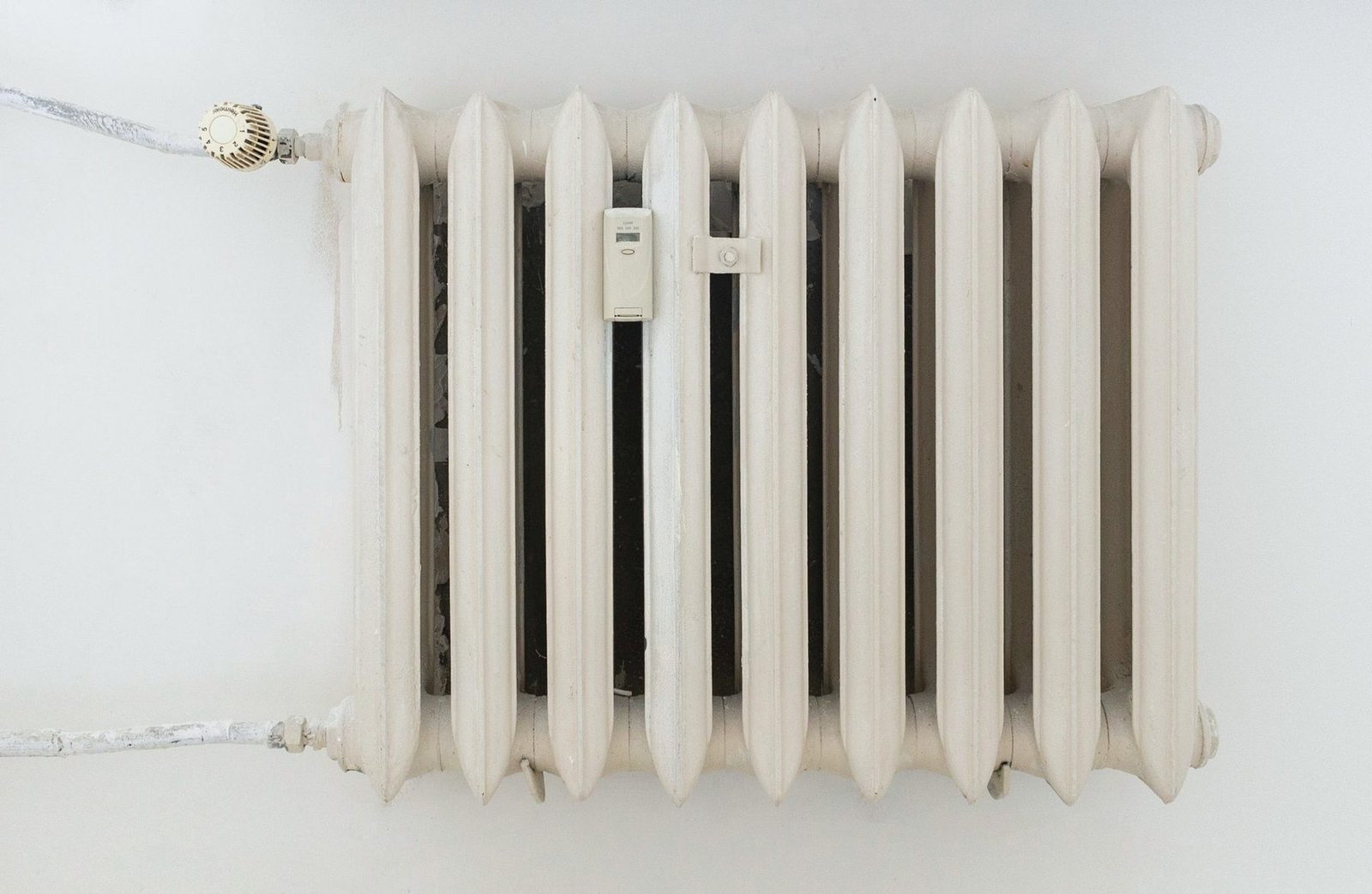 A white cast-iron column radiator against a plain wall